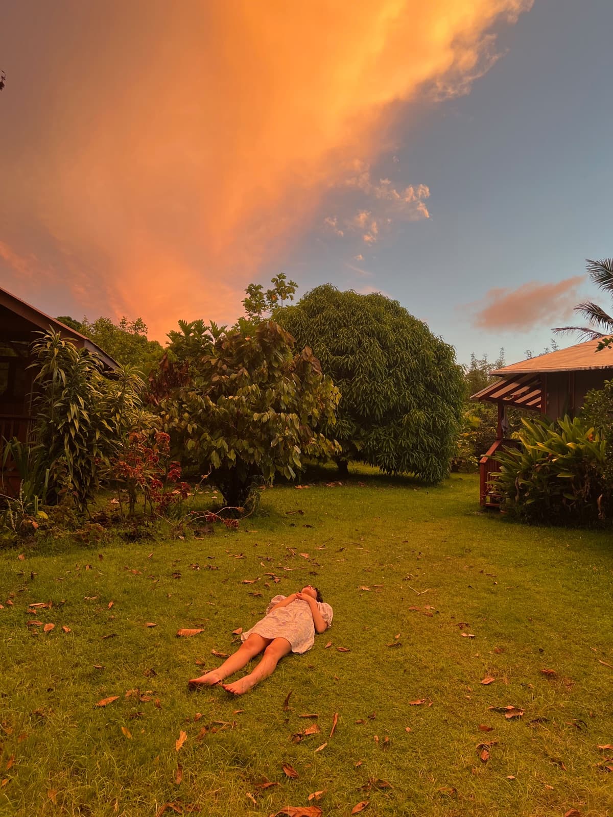 A camper resting in the grass under a golden-hour sky